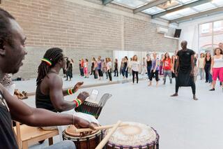 Trommler und Tänzer aus Afrika in einem Unterrichtsstudio.