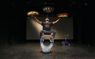 Zwei Tänzer die gemeinsam eine akrobatische Figur bilden.