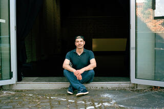 Paolo Fossa sitzt im Eingang eines Studios des tanzhaus nrw.
