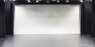 Weiße Leinwand umranden von schwarzen Vorhängen