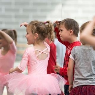 Tanzende Kinder, die nach links gucken.