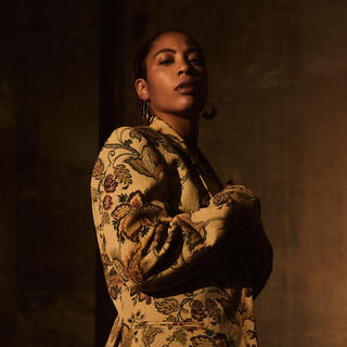 dunkles Bild, Frau mit alter floraler Jacke, guckt ernst