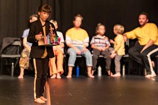 Eine Darstellerin des Stücks Mischpoke, ein etwa 6-jähriges Mädchen, betritt die Bühne