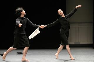 Ein Tänzer und eine Tänzerin im schwarzen Kostüm gekleidet tanzen