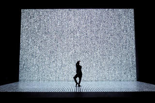 Tanzender Mann alleine auf großer Bühne voll Pixel.