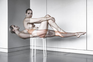 Tänzerin bewegt sich auf einem Stuhl, ihre Bewegungen verschwimmen