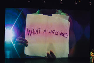 Auf dem Bildschirm hinter Panaibra steht "What an ugly world".