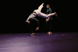 Zwei urbane Tänzer performen auf einer Bühne.
