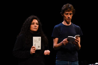 Tammara Leites und Simon Senn auf einer Bühne. Sie halten beide ein Buch.